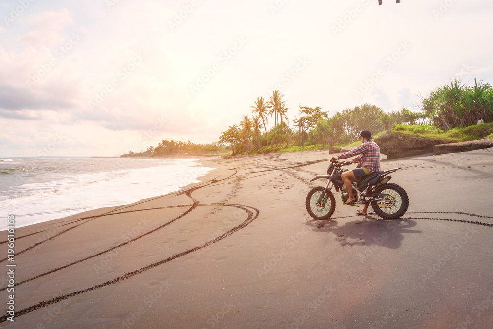Riding motorbike. A man rides his mountain bike on a beach in Bali