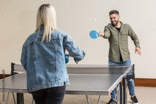 Фотография Cheerful friends playing ping pong
