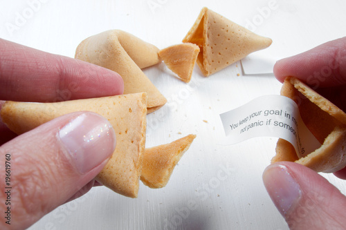 Fortune cookies in hands with advices, motivation mottos and blank space for copy