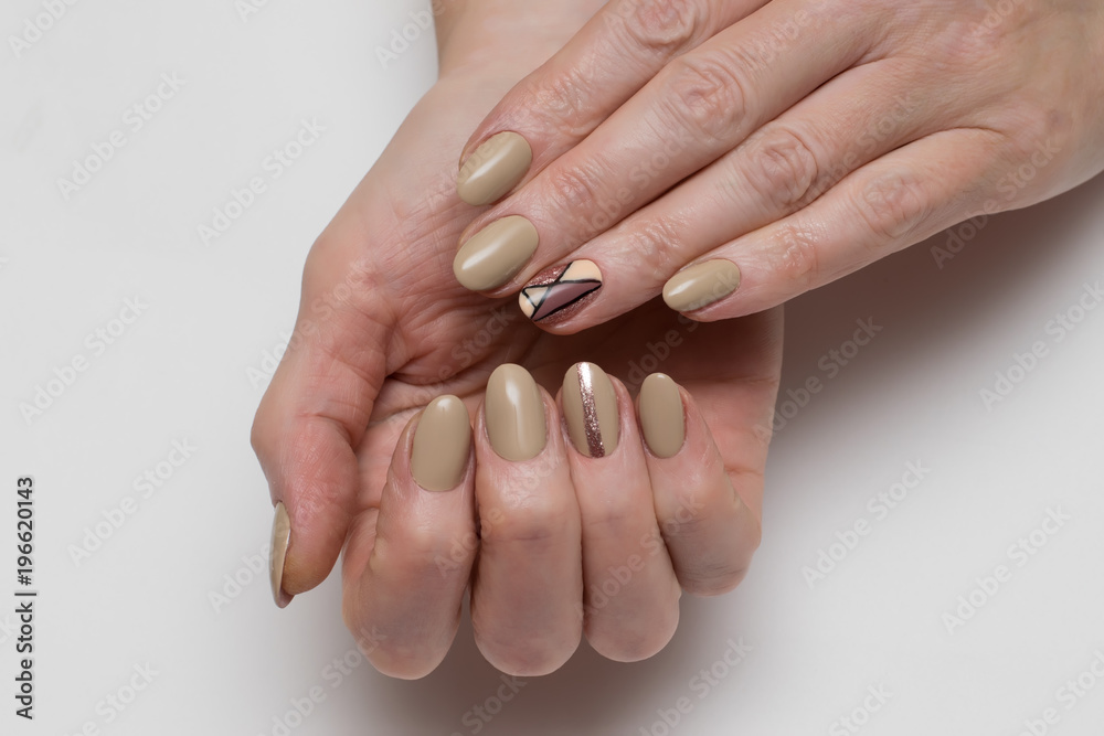 summer beige manicure on short oval nails with a gold stripe and rhombuses  foto de Stock | Adobe Stock