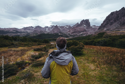 One man stands in front of mountains