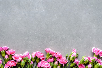 Floral border with spring flowers on gray background, flat lay, top view