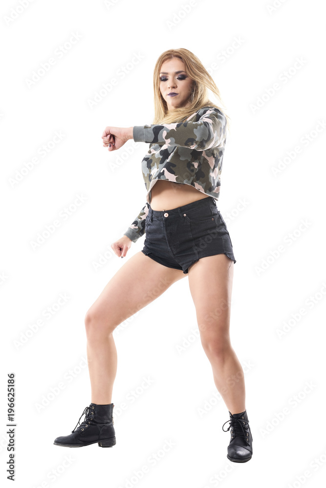 Dancehall confident female performer dancing and moving with clenched fist and hair toss. Full body isolated on white background. Dancehall confident female performer dancing and moving with clenched fist and hair toss. Full body isolated on white background.