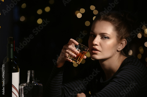Young woman drinking alcohol in bar photo