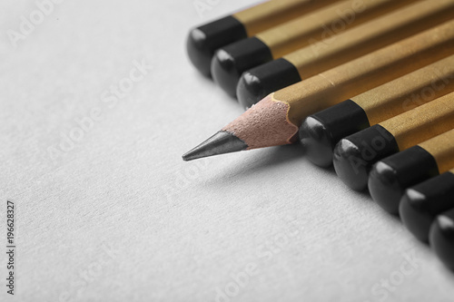 One pencil standing out from others on color background. Difference and uniqueness concept