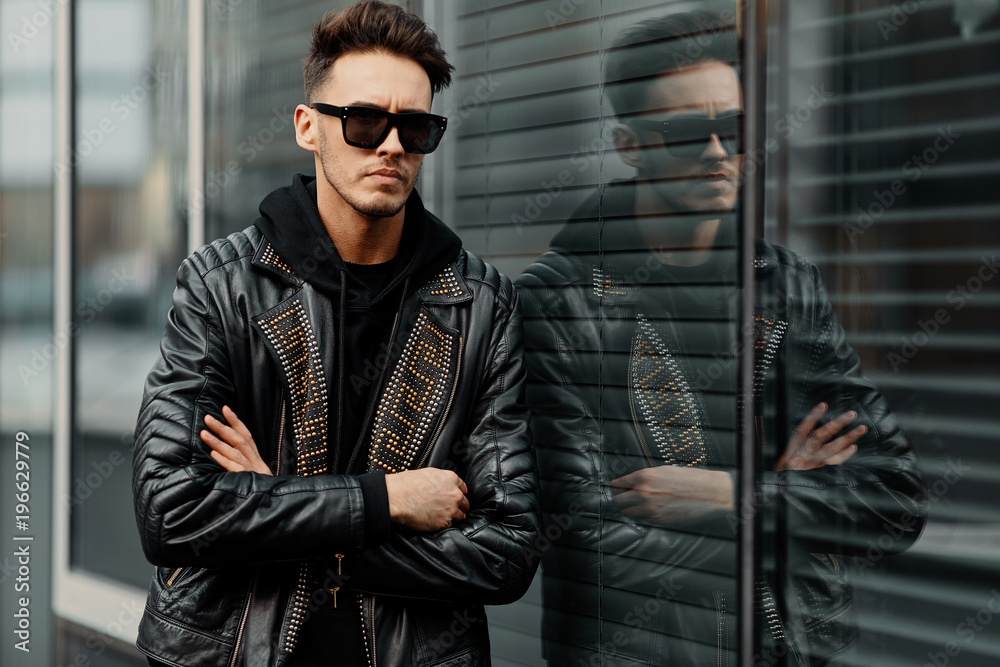 Model looking man stand on the city street with cars background, look on his watch and around Model looking man stand on the city street with cars background, look on his watch and around