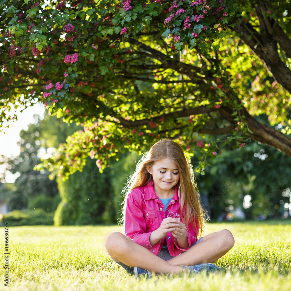 Pretty smiling girl in pink blossom garden. Family Holiday	