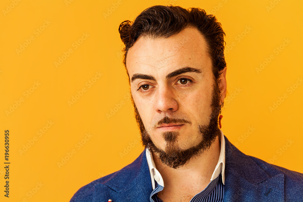 Fototapeta premium Man closeup portrait wearing blue jacket on yellow background