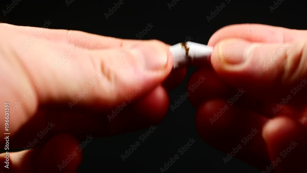Quit smoking - male hand crushing cigarette Quit smoking - male hand crushing cigarette