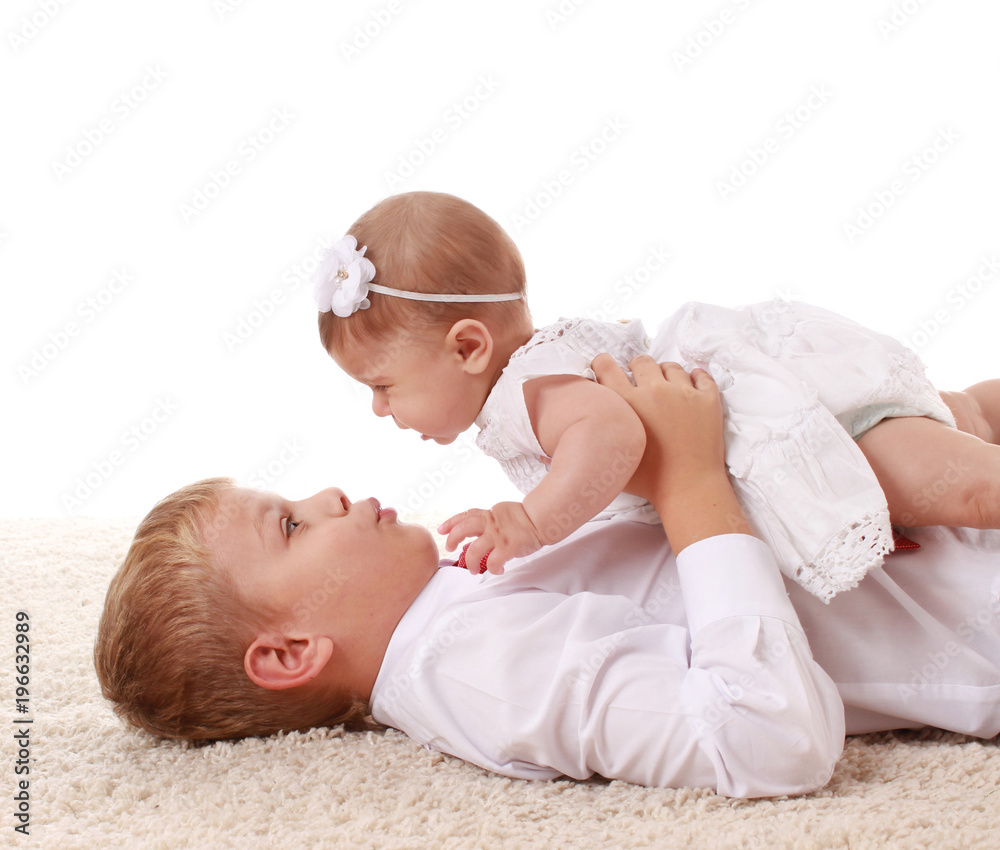 Happy laughing boy holding his sleeping newborn baby little sister. Family love. Happy laughing boy holding his sleeping newborn baby little sister. Family love.