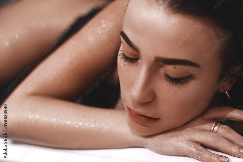 Naklejka premium girl in the bathtub with blue water. girl in lingerie with wet hair. 