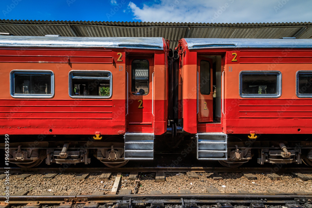 Auf dem Bahnhof wartet ein roter  Zug auf Passagiere,  Sri Lanka