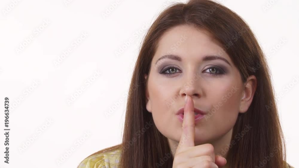 Girl asking for silence or secrecy with finger on lips, hush hand gesture, on white 4K ProRes HQ codec Girl asking for silence or secrecy with finger on lips, hush hand gesture, on white 4K ProRes HQ codec