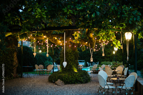 villa garden with large magnolia tree with many lanterns hanging from its branches