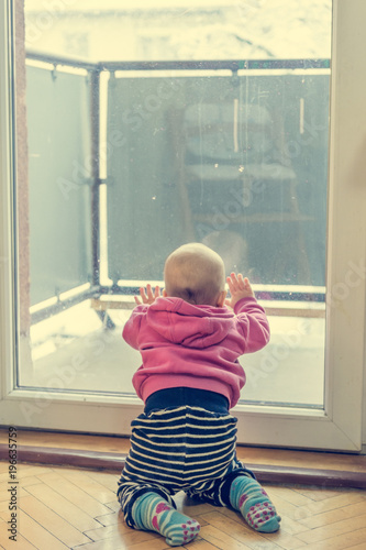 Baby girl looking through balcony.