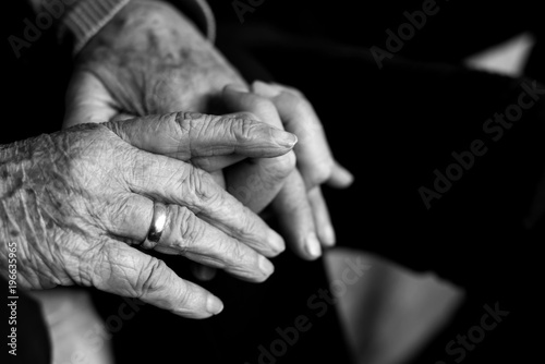 old woman holding the hand of young man