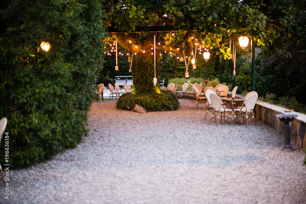 villa garden with large magnolia tree with many lanterns hanging from its branches