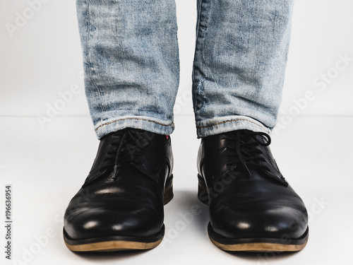 Male legs in stylish, black shoes on a white background. Style, fashion