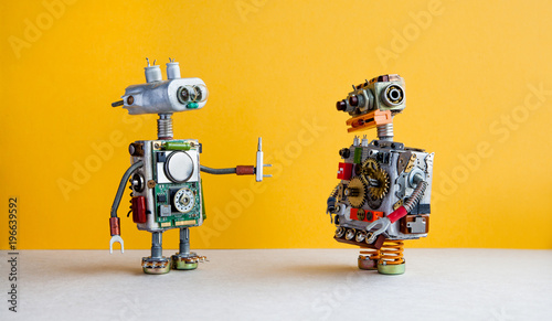 Robots on yellow background. 4th industrial revolution automation concept. Robotic serviceman with screwdriver, creative design toys. Maintenance repair fix concept. photo