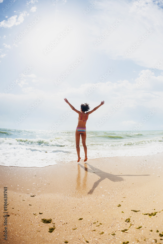 A girl is jumping on the beach. A girl is jumping on the beach.
