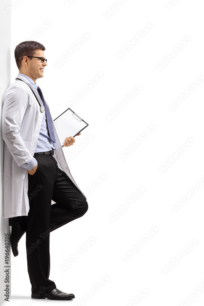 Doctor with a clipboard leaning against a wall Doctor with a clipboard leaning against a wall