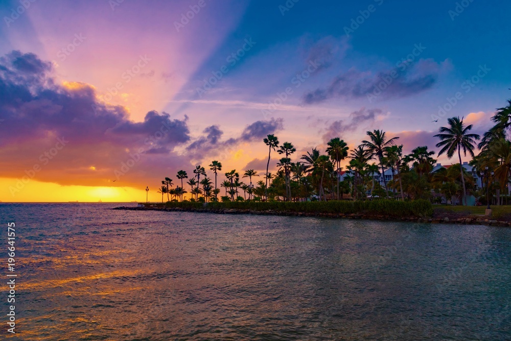 brilliant sunset over the port of Aruba in the Caribbean sea with ships and planes landing