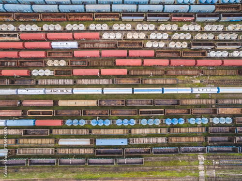 Wagony kolejowe widziane z lotu ptaka. Wagony ustawione w szeregi. Kolorowe linie i wzory utworzone przez wagony kolejowe.