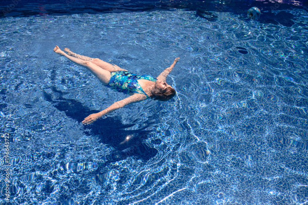 Senior woman floating in pool