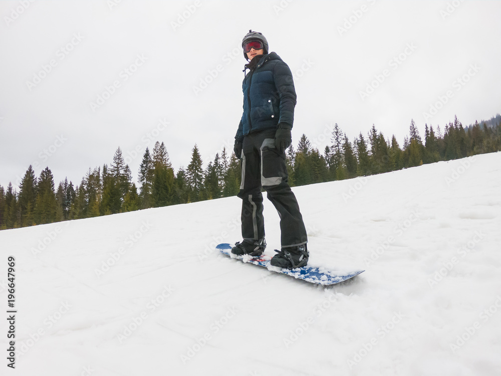 A young guy in sports glasses is riding a snowboard in the mountains in  Transcarpathia, Ukraine. Stock Photo | Adobe Stock