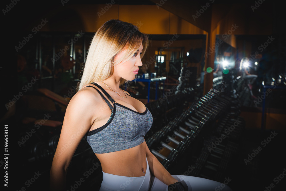 athletic young sexy girl sets weight on barbell in the gym athletic young sexy girl sets weight on barbell in the gym