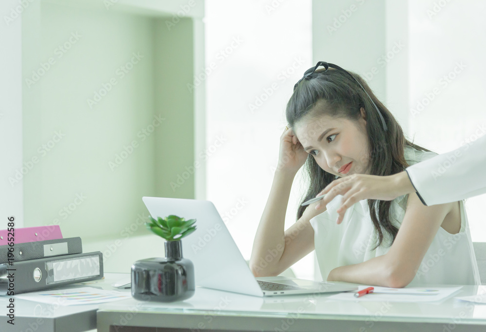 Businesswoman manager has teaching to work for new employee with intention and seriously in the office interior. Businesswoman manager has teaching to work for new employee with intention and seriously in the office interior.