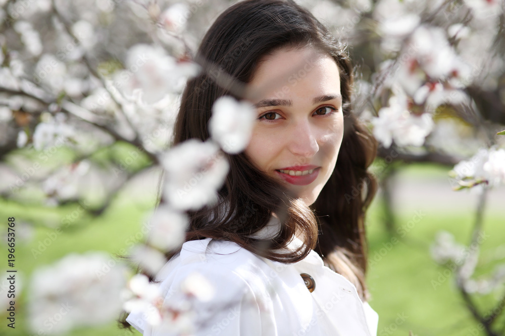 Portrait of a young woman against a background of blossoming apricot Portrait of a young woman against a background of blossoming apricot