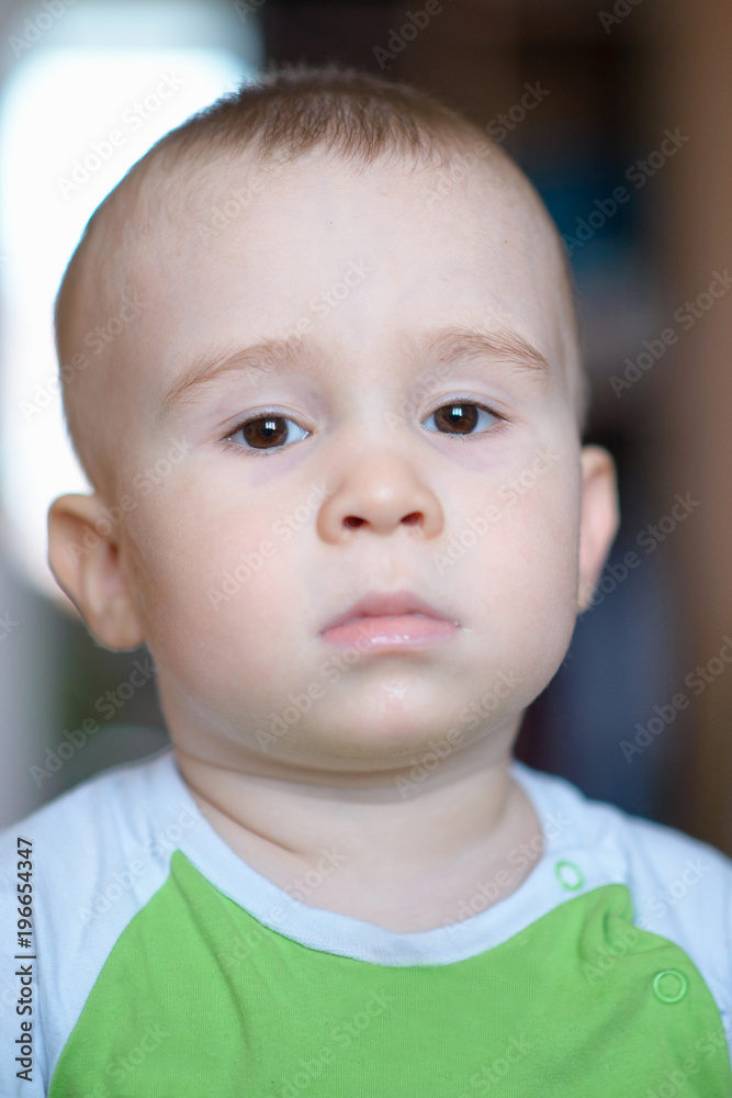 Funny little boy showing emotions, looking serious. Caucasian child 2 years old. Closeup portriat.