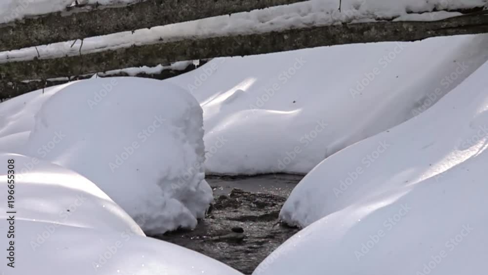 frozen waterfall with ice in a blue and white color in winter. Slow motion
