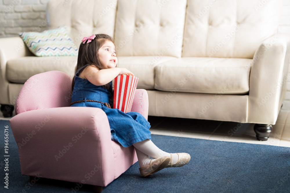 Obraz premium Baby girl enjoying watching tv a home