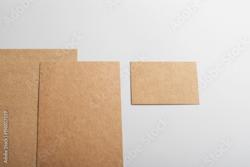 Top view of cardboards and business card in brown color on gray background. Mockup. © Freestocker