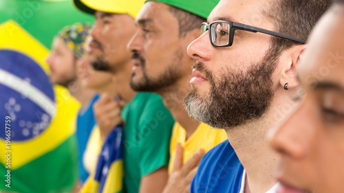 Group of fans watching a match and cheering brazilian team. photo