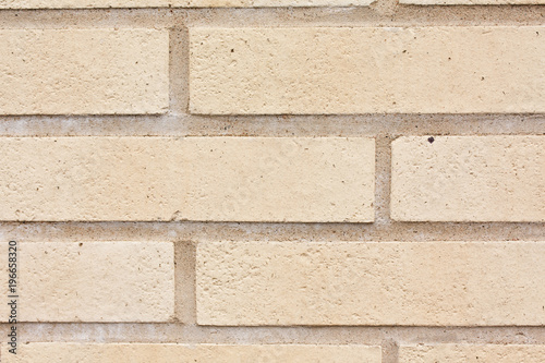 Beige brick outdoor wall of building background close-up.