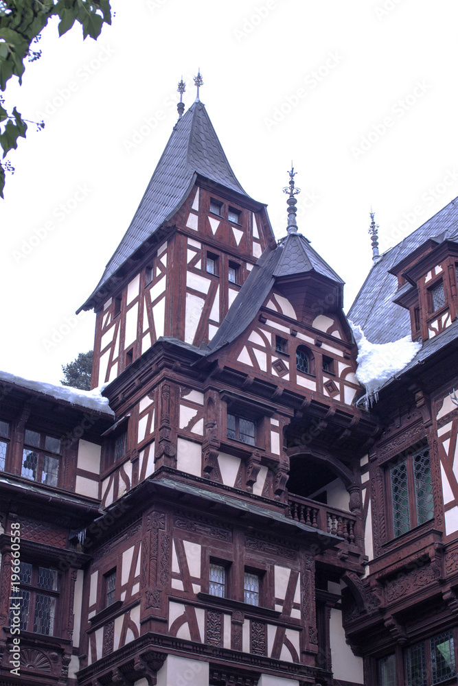 Part of the architecture of Sinai, Romania. An alpine-style building with sharp towers built of wood and stone.