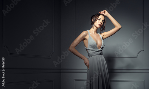 Tablou canvas Beautiful woman wear evening dress and posing in stylish room