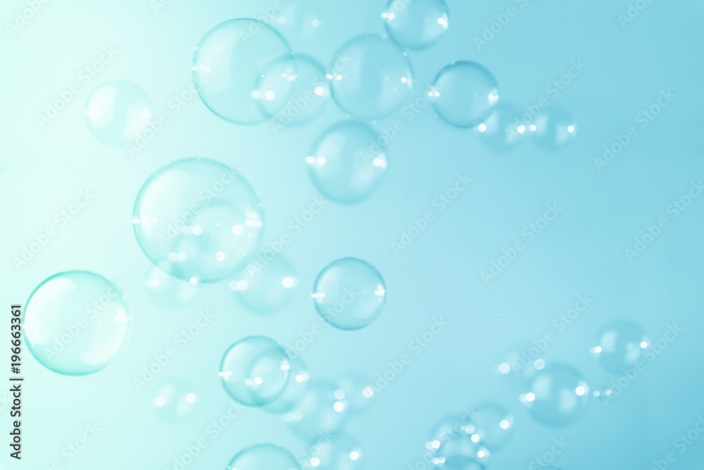 Abstract bright soap bubbles floating on a blue background.