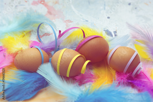 Natural eggs with colorful feathers and confetti - Easter theme