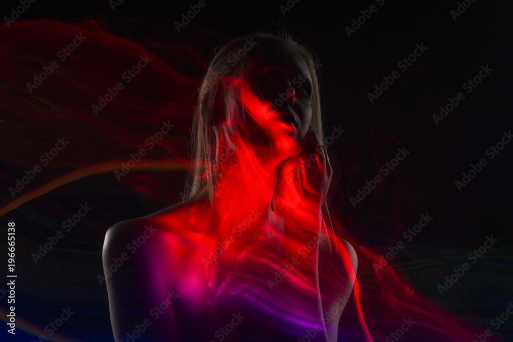 Conceptual avant-garde silhouette portrait of a beautiful blonde girl covered with multicolored lines applied by a lightbrush Conceptual avant-garde silhouette portrait of a beautiful blonde girl covered with multicolored lines applied by a lightbrush