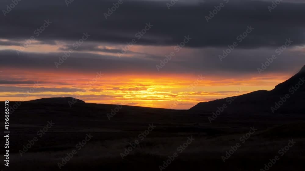 picturesque pink and yellow sunset sky over dark hills in mysterious valley