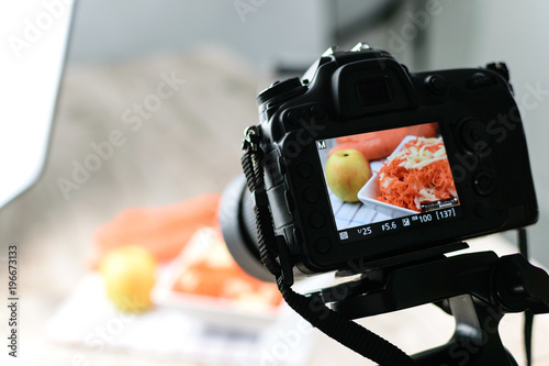 Concept image  -  rear view of DSLR camera making a food photography in the photo studio