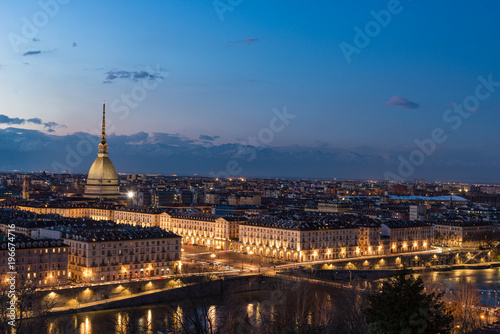 Turin skyline at dusk, panorama cityscape at Torino, Italy, with the Mole Antonelliana over the city. Scenic colorful light and dramatic sky.
