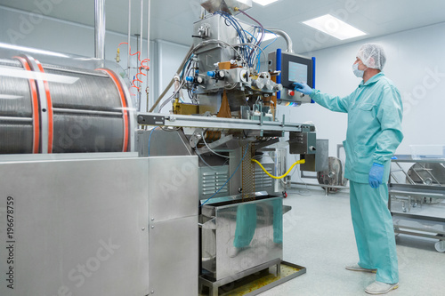 Fotografie Pharmacy industry factory man worker in protective clothing in sterile working c