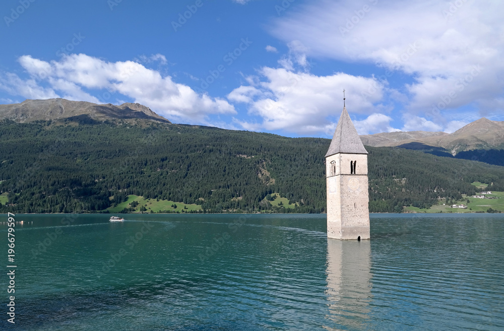 Reschensee mit versunkener Kirche am Reschenpaß in den Alpen - Kirchturm als Wahrzeichen und Sehenswürdigkeit im See