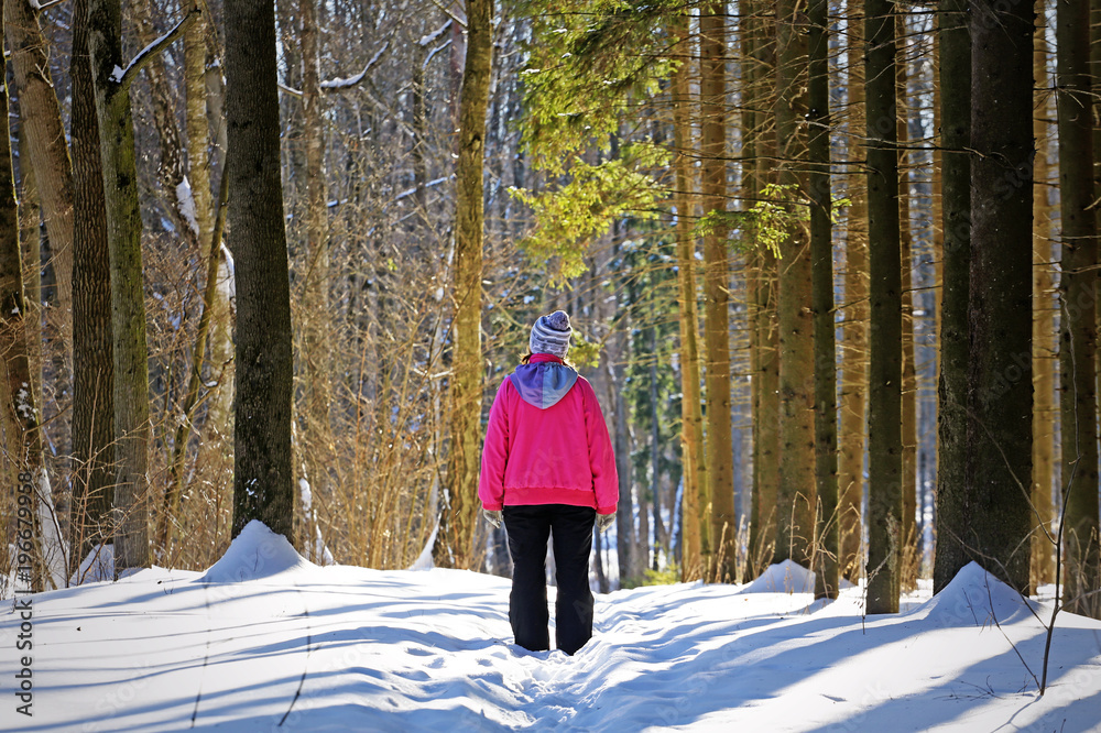 Woman walking in the winter forest
