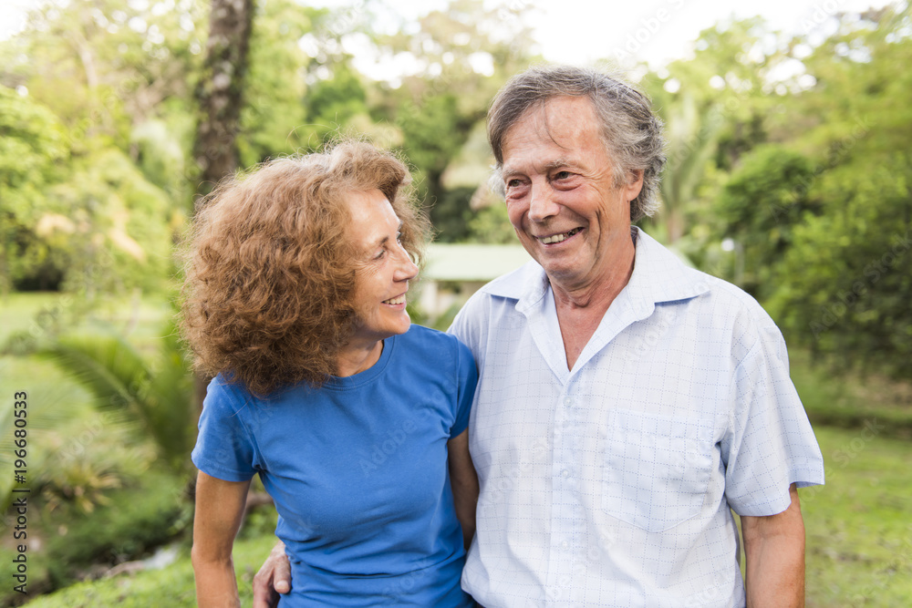 Portrait of a beautiful elderly couple standing embracing outdoors